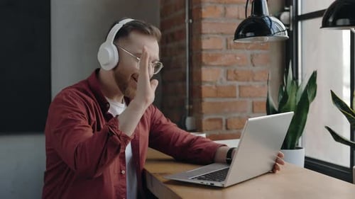 Man on Laptop During Video Call at Work
