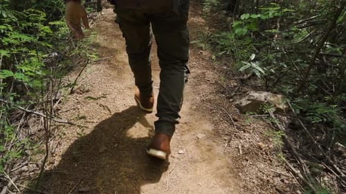 slow-motion of hiking man with trekking boots walking in the natural forest