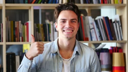 Young Adult Gives a Thumbs Up Indoors