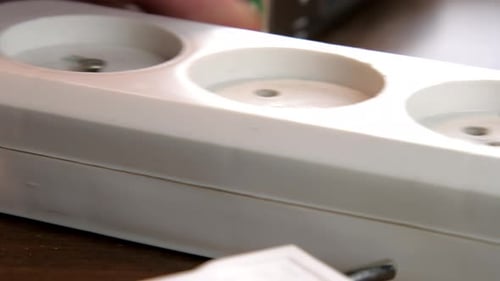 Eletricista experiente desparafusa o cabo de extensão branco