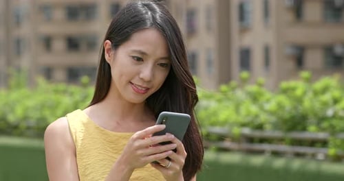 Woman use of cellphone at outdoor park