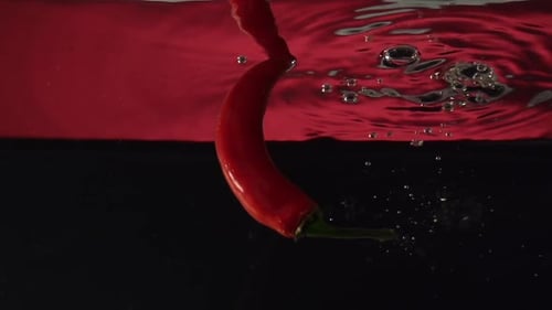 Red Chili Pepper Dropping Into Water