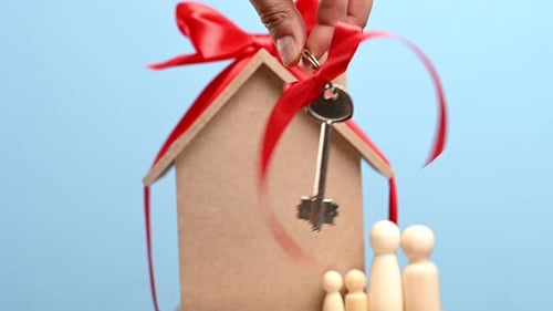 female hand holds a metal key with a red ribbon