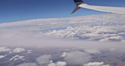 Flying Traveling View From Airplane Window on the Wing on Clouds Blue Sky