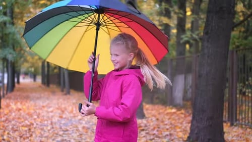 Girl with Colorful Umbrella in Autumn Park