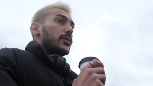 Man Sipping Coffee and Looking Up