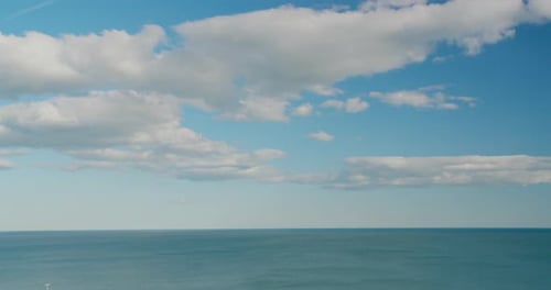 Timelapse. Clouds Fast Motion Above Sea. White Clouds on the Blue Sky Above Calm Sea with Small Wave