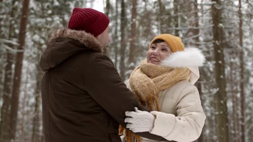 Pareja diversa abrazándose en el bosque de invierno