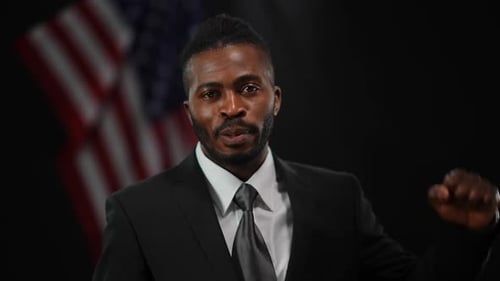 Man in Suit Fists in Front of American Flag