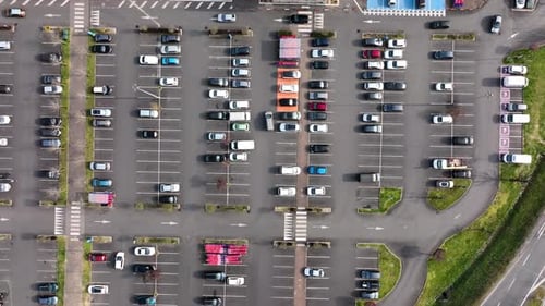 Luftaufnahme vieler bunter Autos, die auf dem Parkplatz geparkt sind, mit Linien und Markierungen für Parkplätze
