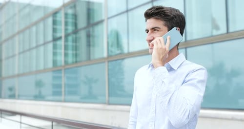 Adult Talking on Mobile Phone Outside Office Building