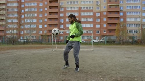 Middle Eastern Sportsman Juggling Soccer Ball on Outdoor Field