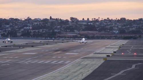 Airplane Takes Off on Runway at Sunset