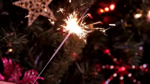 Bright Sparkler Burns Near Christmas Tree Decorations