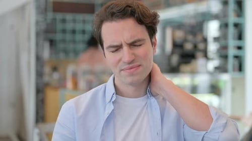 Young Adult with Neck Pain Massaging Neck