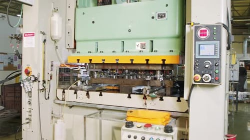 A large industrial punch press forming high precision metal parts for the automotive industry