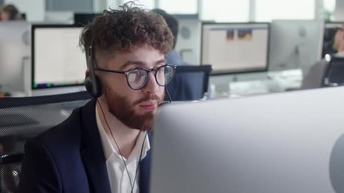 Smiling Man Talking with Headset in Modern Office