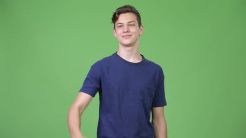 Young Adult Giving Thumbs Up on Green Backdrop