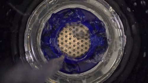 El agua pura se vierte en un dispositivo portátil para la estructuración de la ionización y el enriquecimiento de la alcalinidad