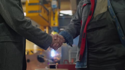 Handshake of Engineer and Technician in Factory