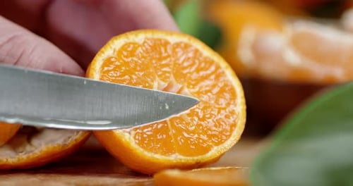Cutting Fresh Tangerine Fruit in Half with Knife
