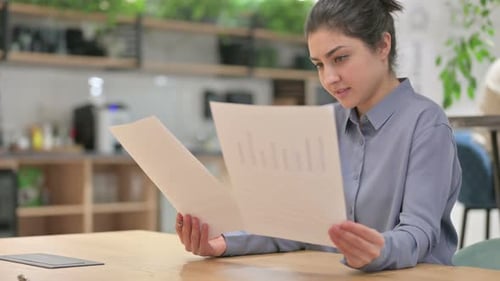 Young Woman Reviews Documents in Office