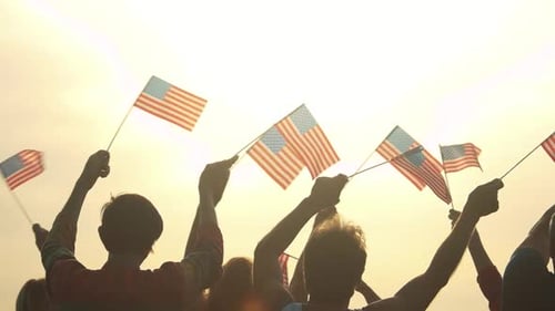People with American Flags at Morning Sky Background