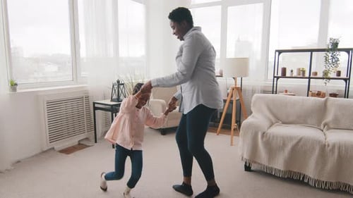 Woman and Child Playfully Spinning in Living Room