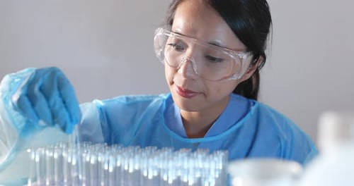 Female Scientist Examining Test Tubes in Laboratory