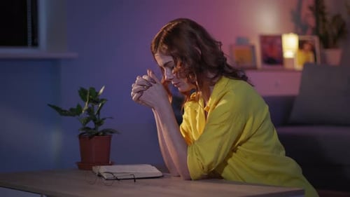 Woman Praying Quietly at Home at Night
