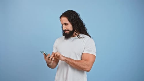 Man with Long Hair Celebrates Good News on Phone
