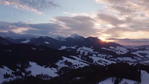 Luftbild Sonnenuntergang über Winter Gebirgsbäume Landschaft Farbige Wolken in der Abenddämmerung