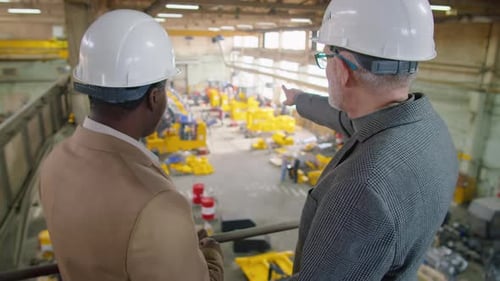 Diverse Engineers Discussing Work in Factory