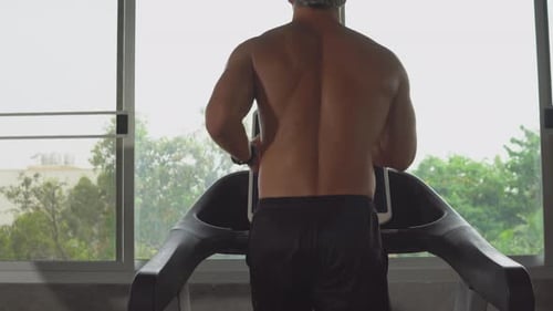 Shirtless Man Working Out on Treadmill in Gym