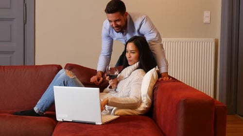 Couple Relaxing at Home with Laptop and Wine