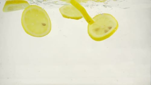 Lemon Slices Fall Into the Water, Slow Motion Close-up