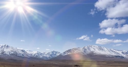 Timelapse of Sun Movement on Crystal Clear Sky with Clouds Over Snow Mountain Top