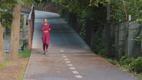 Beautiful Young African American Biracial Female in Summer Sportswear Running in Park During