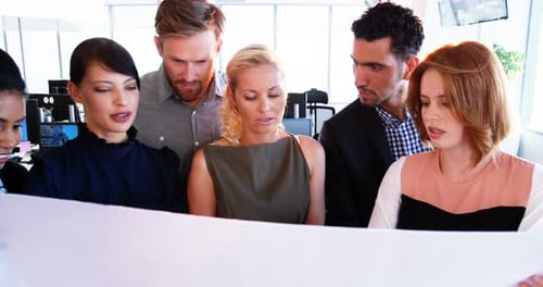 Diverse Team Reviewing Documents Together in Office