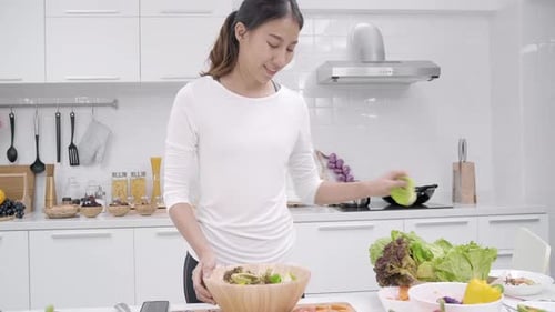 Woman Making a Fresh Healthy Salad in Kitchen