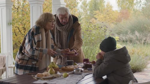 Family Shares Autumn Meal at Outdoor Table