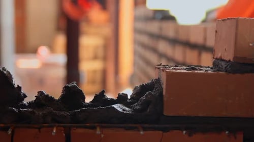Bricklayer Applying Mortar to a Brick Wall