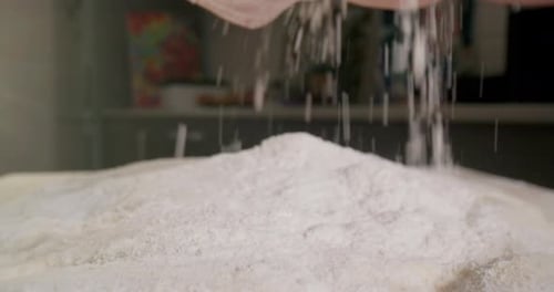 Hands Sifting Flour for Baking in Kitchen