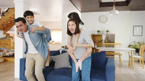 Happy Family Gives Children Piggyback Rides Indoors