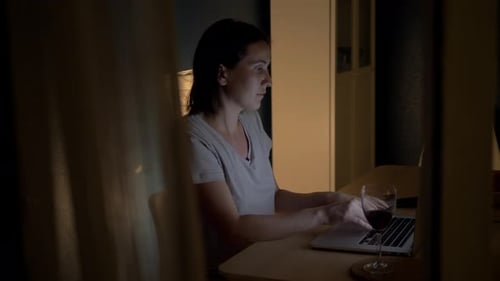 Young Exhausted, Depressed, Concentrated Woman Sitting in Her Room or Office with Windows in the