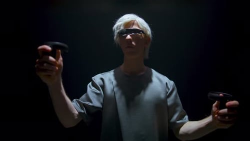 Young Adult Uses Virtual Reality Controllers in Dark