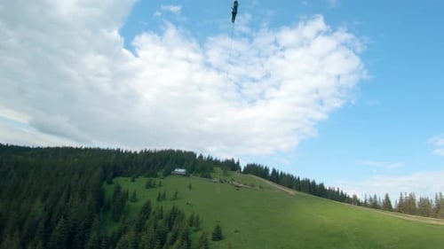 Unusual View of a Woman Riding a Zip Line Among the Mountains