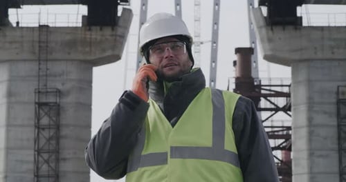 Male Engineer Examining Bridge and Speaking on Cellphone