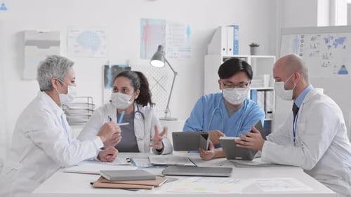 Medical Team Meeting with Tablets in Office