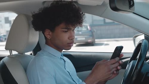 Young Adult Using Phone in Car During Daytime